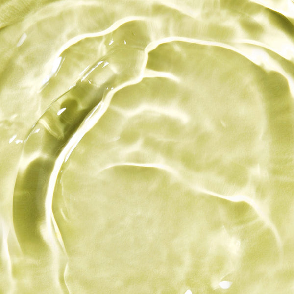 Close-up of golden-yellow hair oil texture with light reflections and smooth, fluid ripples, illustrating the luxurious consistency of the product.
