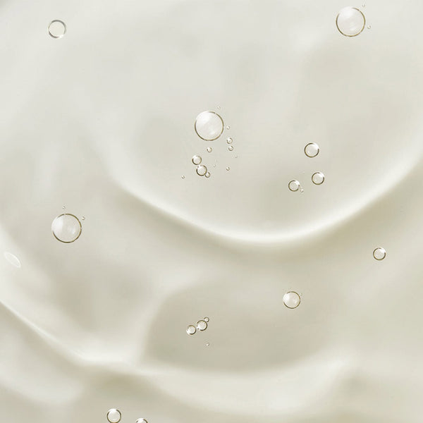 Close-up of clear cuticle oil texture with small air bubbles suspended in a smooth, glossy surface.