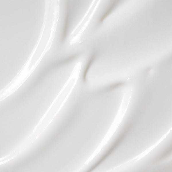 Close-up texture of Tropic’s Super Smooth product, showing a creamy, glossy white surface with soft, smooth swirls.