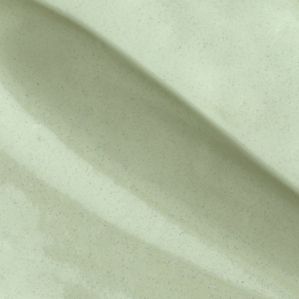 Close-up of Calm & Correct product texture, showing a smooth, light green cream with fine speckles.