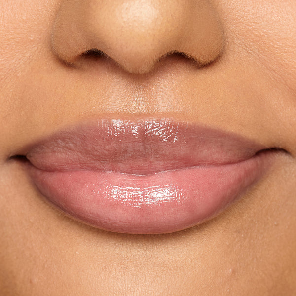 Close-up of model’s lips wearing Tropic Lip Fudge in shade Rosewood, giving a glossy, tinted finish.