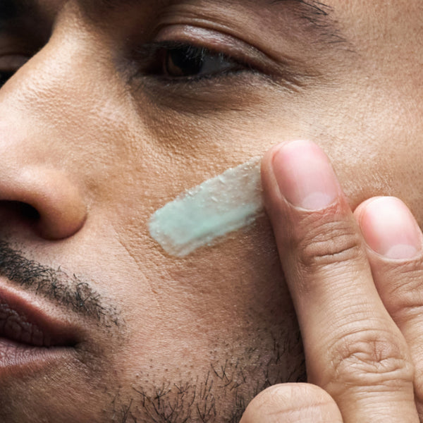 Close-up of Skin Shield SPF moisturiser being applied to skin with fingertips.