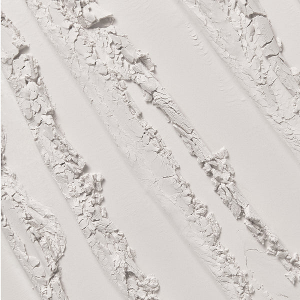 Close-up macro texture of finely milled translucent powder, shown in soft, broken streaks across a smooth surface.