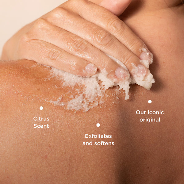 The image shows Tropic Body Smooth Refreshing Polish being applied to the shoulder, highlighting its exfoliating texture. Key product benefits are labeled:

Citrus Scent, offering a refreshing fragrance.
Exfoliates and softens, gently removing dead skin cells for smooth, soft skin.
Our iconic original, emphasising its status as a classic, well-loved product.
The rich scrub and its application suggest a luxurious, spa-like skincare experience.