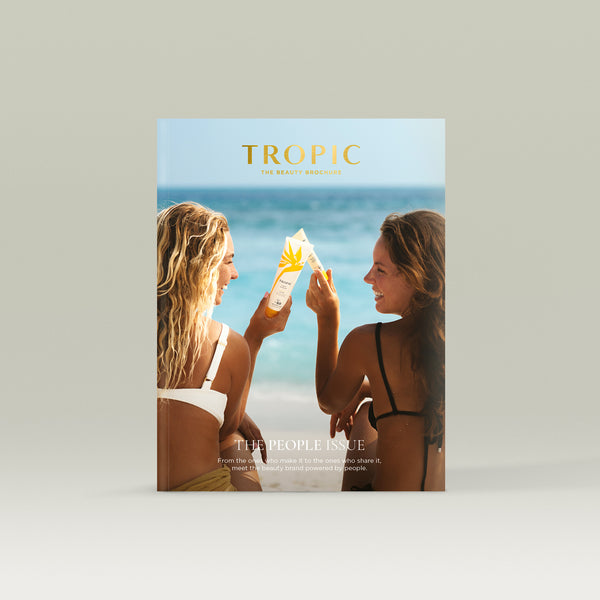 Tropic Beauty Brochure cover showing two women on a beach holding skincare products, highlighting a sunlit, lifestyle-focused “People Issue” theme.