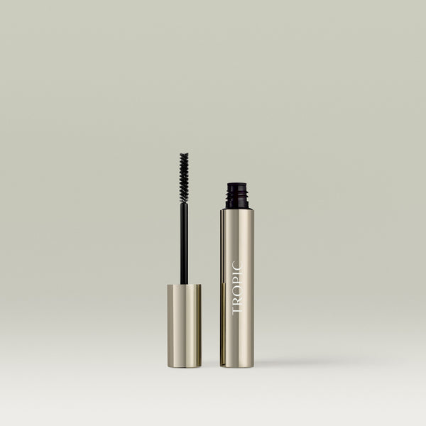Silver tube of Tropic Extension Fibres with the wand removed and standing beside it, showing the fine black brush designed to apply fibre-building lash extensions.