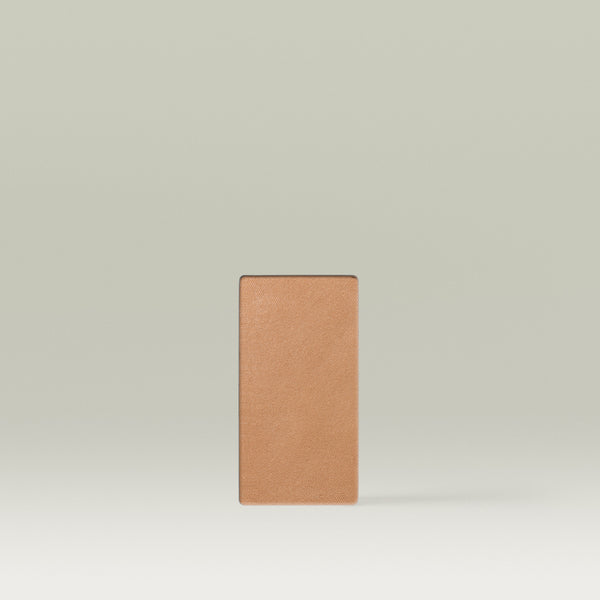 A Tropic Jet Set bronzer refill pan in the shade Bali Bronze, shown as a rectangular medium-sized pressed powder pan in a warm tan tone against a soft neutral background.