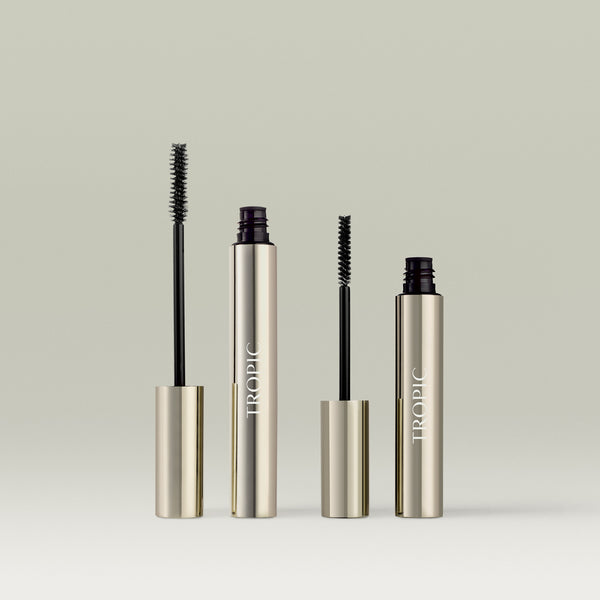 Two silver Tropic tubes side by side: on the left, the opened Lash Extension Mascara with its volumising mascara wand, and on the right, the opened Extension Fibres tube with its finer fibre applicator brush. In shade Black.