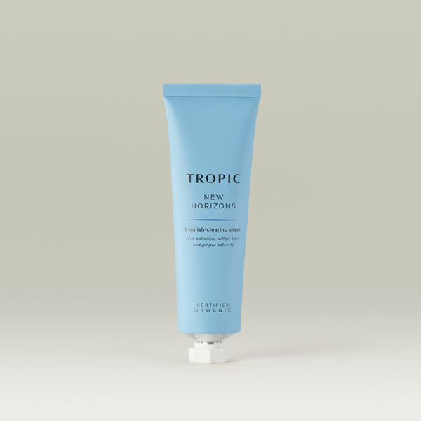 Tropic New Horizons Blemish-Clearing Mask in a light blue tube, formulated with blue spirulina, willow bark, and ginger extracts to purify and balance the skin. With white piercer lid.