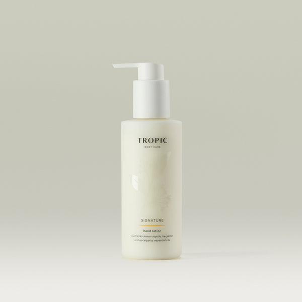 Tropic Signature Hand Lotion in a sleek frosted bottle with a white pump dispenser, displayed against a neutral background.