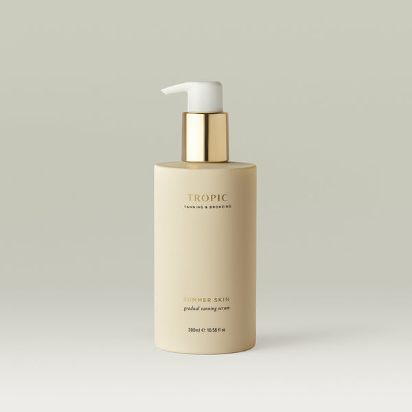 Summer Skin Gradual Tanning Serum by Tropic in a minimalist cream bottle with a gold pump, designed to deliver a natural-looking, buildable glow with skincare benefits.