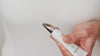 Model dispenses product onto the zamac applicator by squeezing the tube. They dab it under their eye and blend the product in with applicator.