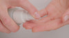 Model dispenses Skin Re-leaf moisturiser into their hands revealing the rich green texture. They rub it into their hands and apply to their face applying to the nose and sweeping across the rest of their face also including application to the neck.