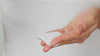 Model shakes the Juicy Greens Toner onto a cotton pad and sweeps the pad over her face.