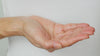 Model uses the pipette to drop a few drops of Glow Berry serum into the palm of their hand. They then press into their skin.